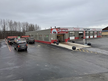 Automatic car wash in Wasilla, AK displaying the outside of the car wash with two lanes, one for Members and one for anyone stopping by to clean their car